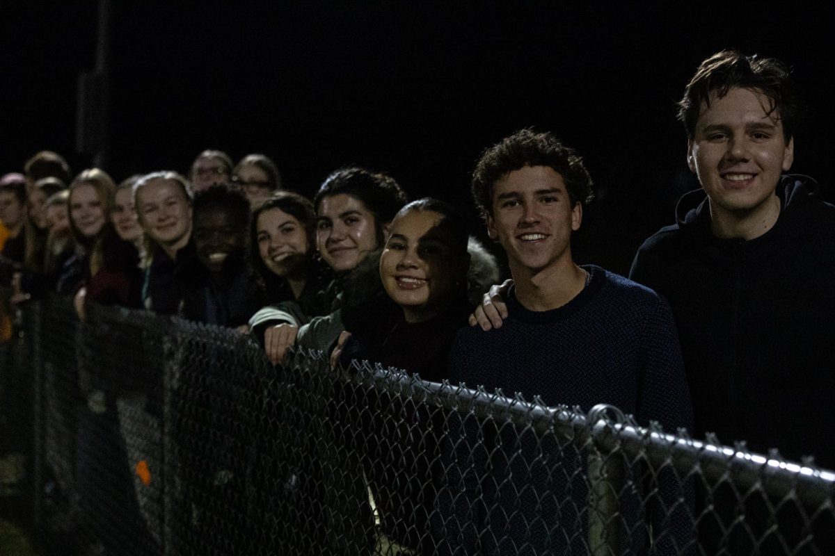 Students smile as they cheer on the team