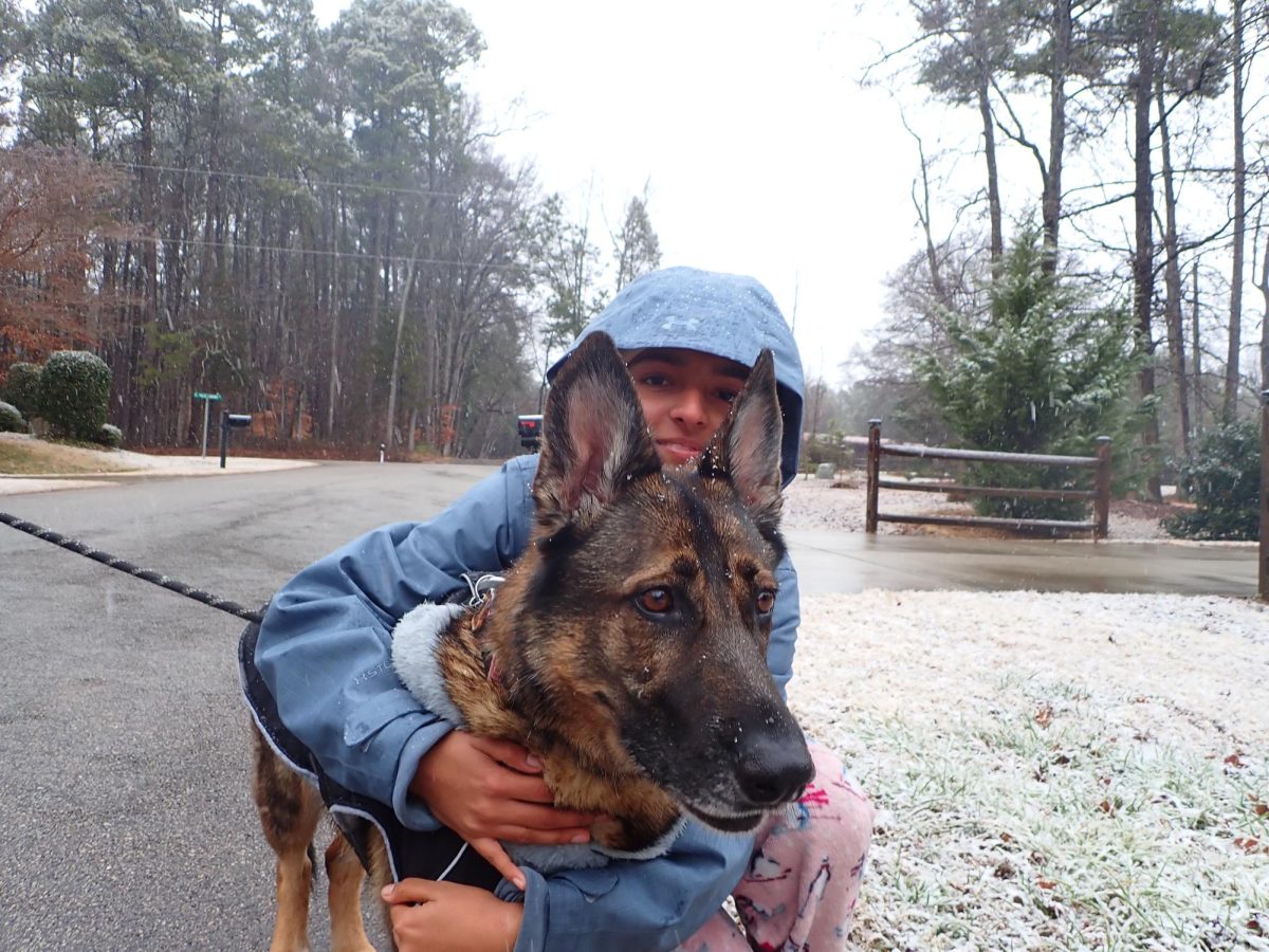 Junior Dana Sudhir poses in the snow with her dog, Pepper.