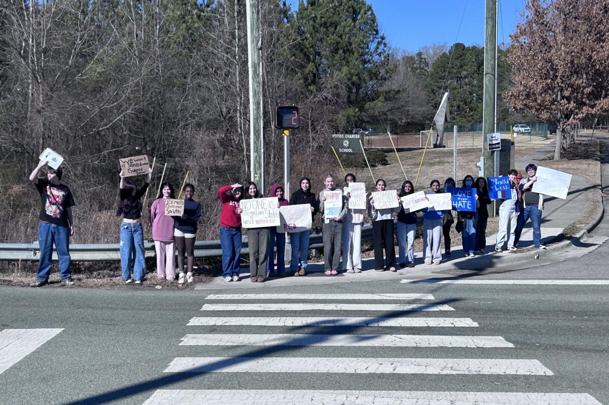 Students walk out against ICE at the intersection next to Woods.